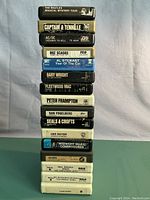 Stack of 16 vintage 8 track tapes featuring various classic rock artists and albums