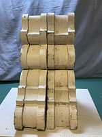 Front view of two vintage wood corbels side by side showing distressed white paint and scroll design.