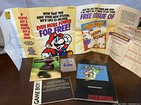 Overall display of the Nintendo GameBoy Super Mario Land cartridge, instruction booklets, Nintendo GameBoy manual, and promotional flyers.