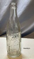 Front view of clear glass soda bottle embossed with 'Hambly's' brand from Hambly Beverages, Oshawa.