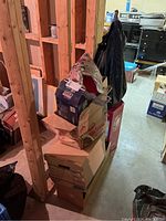 Stack of boxes and bags containing Christmas decorations including tins and Santa figure.