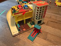 Full view of the Parking Ramp and Service Center playset including cars and elevator, showing the layout and base board graphics.