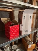 Original Fitz Floyd boxed figurines and packaging on metal shelving in basement.