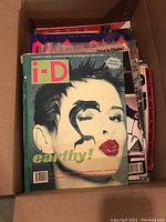 Box with i-D magazine on top featuring a woman with artistic makeup and lizard design on cover