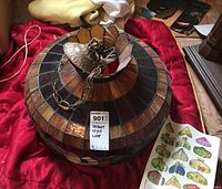 Photo of Tiffany style stained glass ceiling lamp on a red cloth showing the dome shade with a metal ceiling mount and chain.