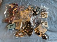 Photo showing assorted costume jewelry in plastic bags and on display cards including earrings and bracelets