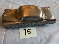 Top and side view showing detailing and proportions of metal car coin bank.