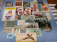Image showing a diverse selection of ephemera spread over a surface including tickets, postcards, a Playbill, photographs and greeting cards.