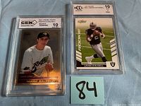 Rocco Baldelli 2000 Chrome Traded rookie baseball card graded Gem Mint 10 by GPK and Jamarcus Russell 2000 Score rookie football card graded 10 by BCCG shown side by side in protective cases.