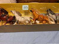 Four Grand Champion horse figurines in original packaging, clearly visible with braided manes and detailed coloring