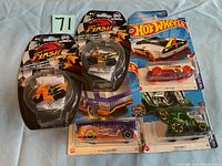 Lot of 3 Hot Wheels cars and 2 Flash Mini Cycles in original packaging laid out on a white surface.