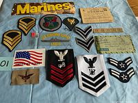 Top view of military lot patches, ration book, coupons and stripes arranged on surface, showing all included items clearly.