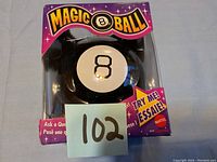 Magic 8 Ball in its original retail packaging showing the front of the box with slight damage on the bottom left corner.