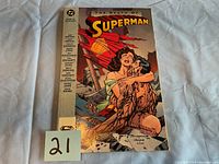 Photo of front cover of The Death of Superman comic book showing title, DC logo, price, and cover art of Lois Lane holding injured Superman.