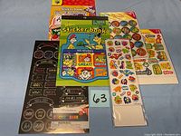 Photo of multiple sticker books and sheets arranged on a surface showing variety and quantity