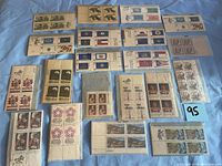Full lot of multiple blocks of unused U.S. postage stamps laid out on a blue background. Various themes and dates.