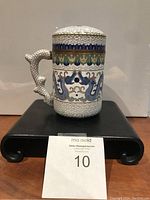 Side view of the cloisonné teacup showing handle and dragon motif.