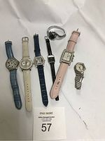 Seven watches laid out in a row showing variety in band materials and face shapes