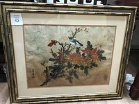 Full view of the framed Asian painting with bird and floral branch.