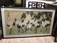 Full view of the framed Asian painting showing cranes and pine branches with Asian calligraphy.
