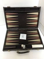 Open backgammon set in folding brown case showing game board with triangular points and checkers arranged in trays.