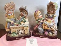 Two Louis Dionne sculptures featuring children in vintage clothing involved in domestic activities, photographed from the front showing full views.