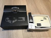 The original black box next to the projector and remote control.