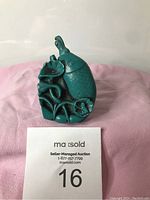 Front view of carved turquoise fish snuff bottle with detailed scales and seaweed motif