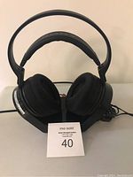 Front view of Sony headphones showing padded ear cups and adjustable headband placed on a stand.