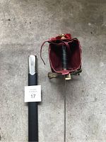 Photo of the rapier sword partially sheathed with the top of the basket hilt and scabbard throat visible