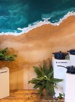 Photo of two hand painted 4ft x 8ft wooden backdrop pieces showing detailed beach scene with ocean waves, foam, and sandy shore.