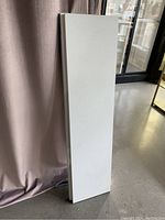 Standing view of one IKEA Bergshult white shelf panel, rectangular shape with smooth finish