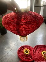 Red diamond-shaped lantern held up to light to show texture and details