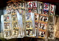 Photo shows numerous 1990-1991 ProSet NHL hockey cards arranged in transparent protective pages. The cards depict various players in hockey uniforms in different team colors.