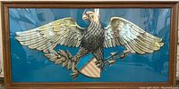Overall view of the framed print showing the Great Seal of the United States against a blue background with brown wooden frame.
