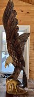 Side view of the carved eagle showing detailed feather carving and painted beak and talons