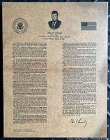 Full view photo of laminated parchment reproduction of JFK's Inaugural Address on board.