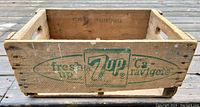 Side view of the wooden crate showing the green vintage 7UP logo with text.