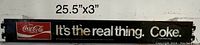 Photo of vintage Coca-Cola metal pushbar sign showing full length with text 'It's the real thing. Coke.' and Coca-Cola logo.