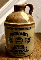 Front view of vintage miniature Platte Valley Straight Corn Whiskey jug with text and logo visible.