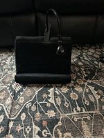 Cushioned black tablet holder with strap and bottom rest, setup for tablet use