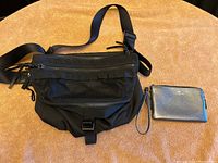Lululemon black crossbody bag with mesh pocket and Coach black leather wristlet side by side