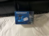Photo of box showing the Mastercraft brand and model details of the random orbit sander.