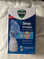 Front side of the Vicks Sinus Inhaler box showing branding, product name, and key functions including germ free steam and treatment duration.