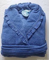 Folded view of the royal blue Alpine spa bathrobe highlighting soft plush texture and ruffled collar.