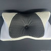 Front view of the SAHEYER cervical neck pillow showing the textured dark grey center and white quilted sides with mesh panels.