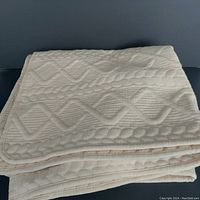 Folded creamy white rug showing thickness and texture