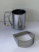Photo of the Fox Run stainless steel flour sifter showing its rectangular handle and push lever.