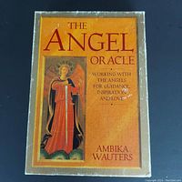 Front cover of The Angel Oracle book showing angel illustration and title. Worn surface and edges visible.