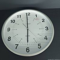 Full view of the round wall clock showing the entire face with numerals and hands at 6:00